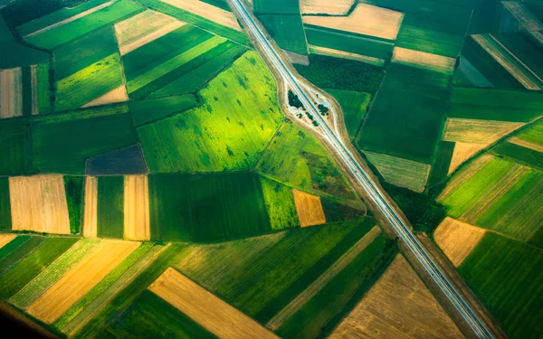 Luchtfoto van een vliegtuig, bovenaanzicht, weg door de velden — Stockfoto