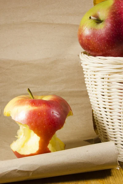 Apple core and a basket with apples — Stock Photo, Image