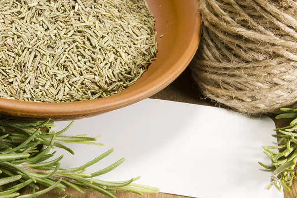 Fresh rosemary and a bowl with dried — Stock Photo, Image
