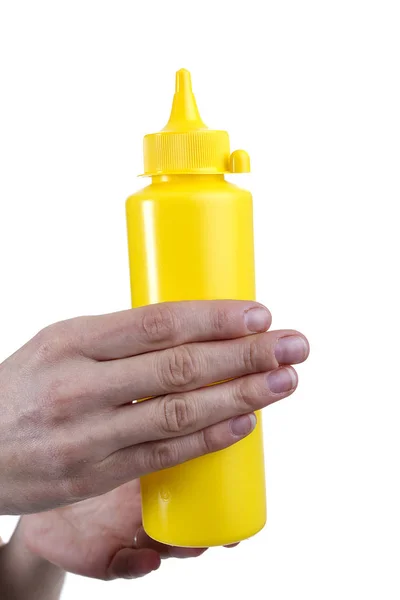 Tubo amarelo para molhos em mãos femininas — Fotografia de Stock