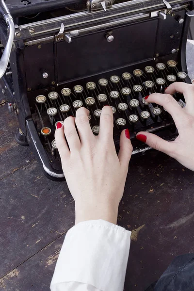 Handen van een jonge vrouw afgedrukt op een typemachine — Stockfoto