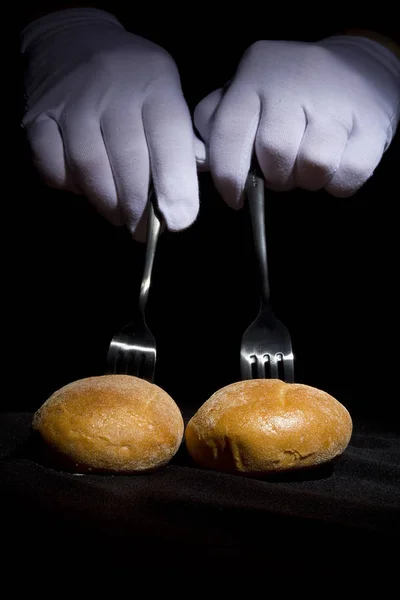 Buns nos garfos e mãos em luvas brancas — Fotografia de Stock