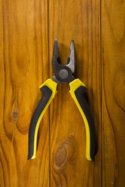 multitool pliers on wooden background clipart