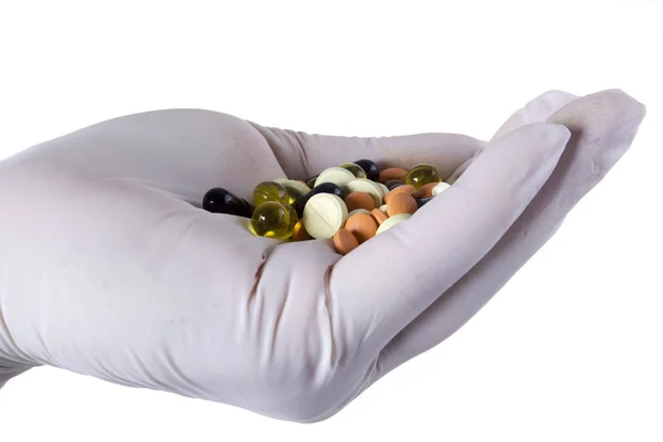 Pharmaceutical pills on a hand in latex glove — Stock Photo, Image