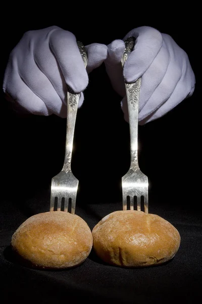 Buns nos garfos e mãos em luvas brancas — Fotografia de Stock