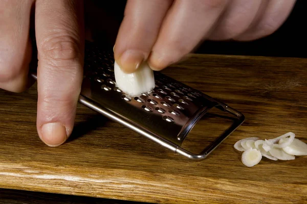 Female hands grind garlic — Stock Photo, Image