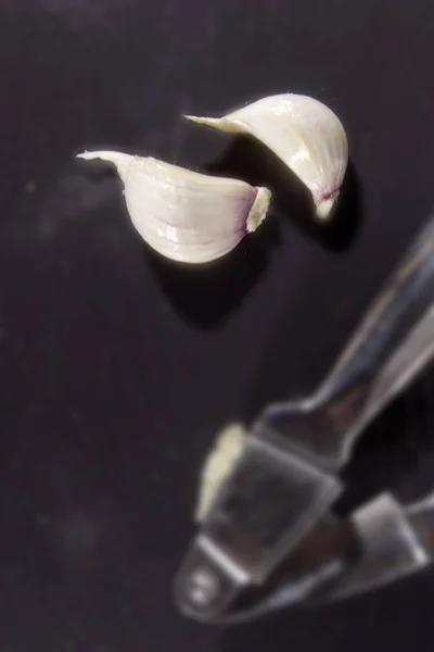 Garlic press and cloves of garlic — Stock Photo, Image