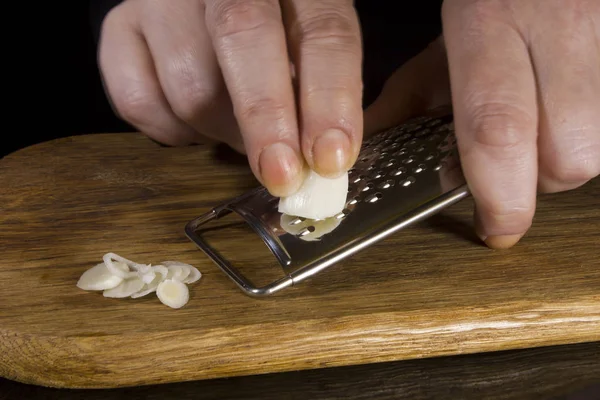 Female hands grind garlic — Stock Photo, Image