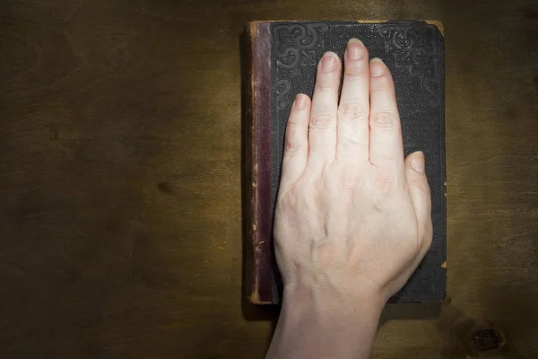 Weibliche Hand auf der Bibel — Stockfoto