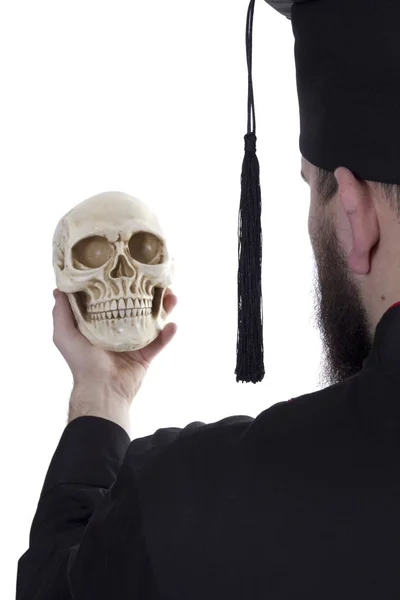 Young man in a graduate hat with a skull — Stock Photo, Image