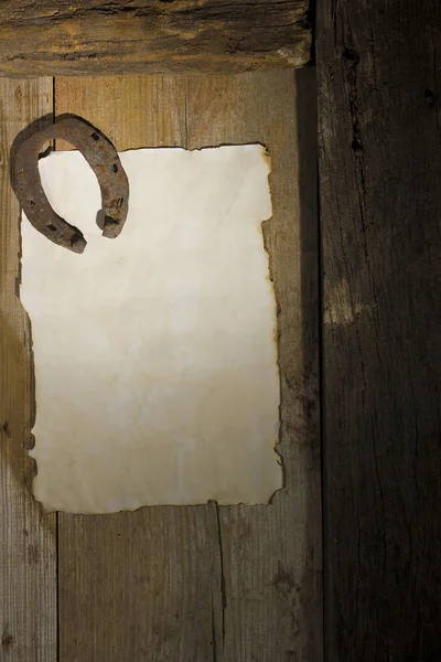 Rusty horseshoe and a sheet of paper on the door — Stock Photo, Image