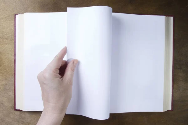 Mão vira uma folha em branco do livro — Fotografia de Stock