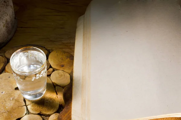 Glass of vodka and an ancient book — Stock Photo, Image