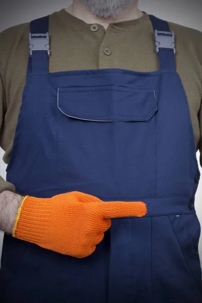 Рабочие руки в оранжевых перчатках — стоковое фото