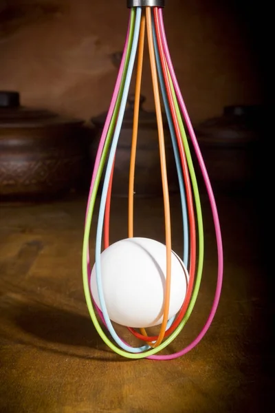 Egg in the culinary whisk — Stock Photo, Image