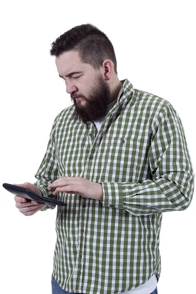 Young bearded man counts on a calculator — Stock Photo, Image