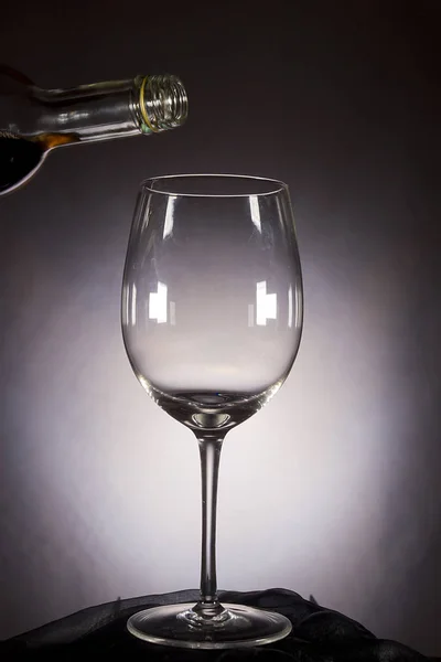 Wijn is in het glas gegoten uit de fles — Stockfoto