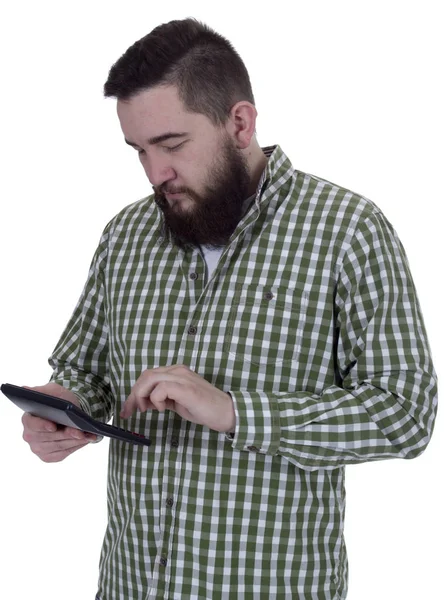 Молодой бородатый человек рассчитывает на калькулятор — стоковое фото