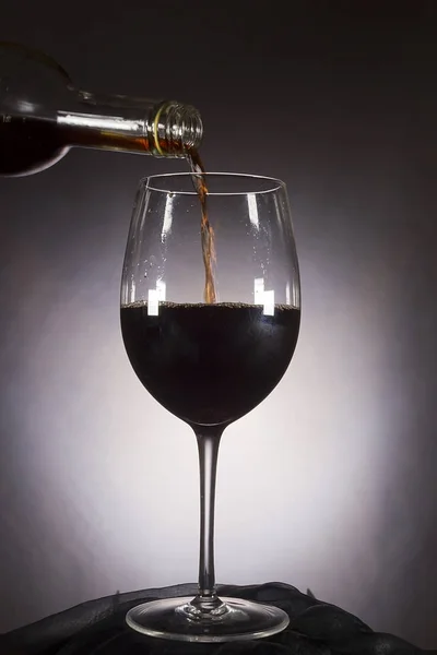 El vino se vierte de la botella en el vaso — Foto de Stock