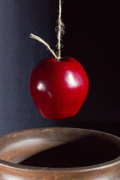 Apple on the rope is lowered into a pot — Stock Photo, Image