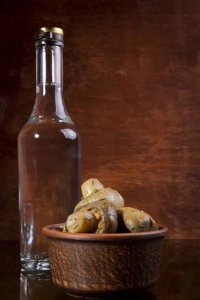 Marinierte Pilze und eine Flasche Wodka — Stockfoto