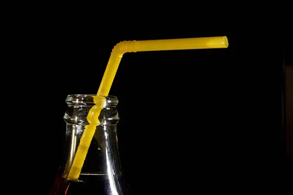 O pescoço de uma garrafa de cola com uma palha — Fotografia de Stock