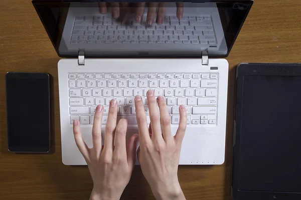 Las manos femeninas están trabajando en una computadora portátil — Foto de Stock