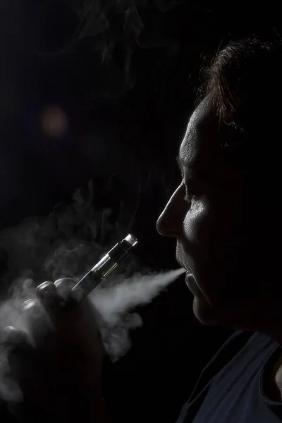 Силуэт женщины с электронной сигаретой — стоковое фото
