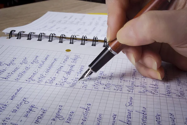 La mano escribe en un cuaderno —  Fotos de Stock