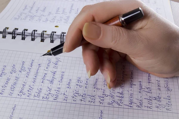 De hand schrijft in een notitieboekje — Stockfoto