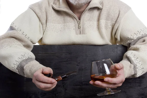 Mäns händer med cognac och en tub — Stockfoto