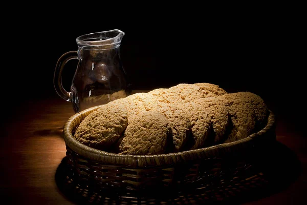 Galletas en una cesta y una jarra —  Fotos de Stock