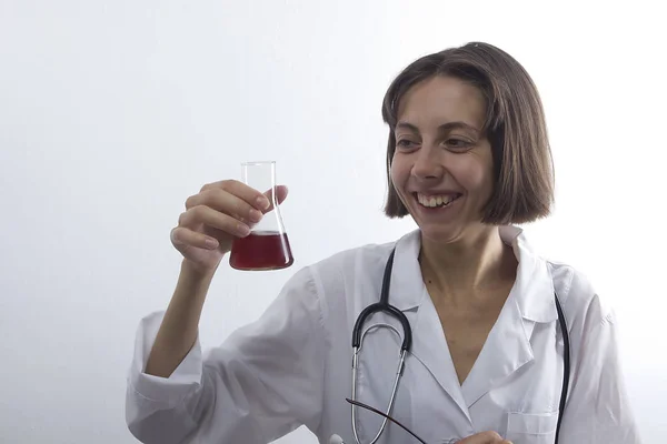 Mujer doctora con estetoscopio y frasco — Foto de Stock