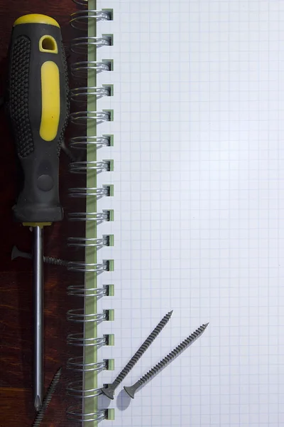 Screwdriver and notebook — Stock Photo, Image