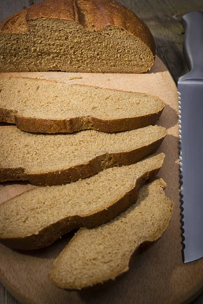 Pão fatiado em uma tábua de corte — Fotografia de Stock