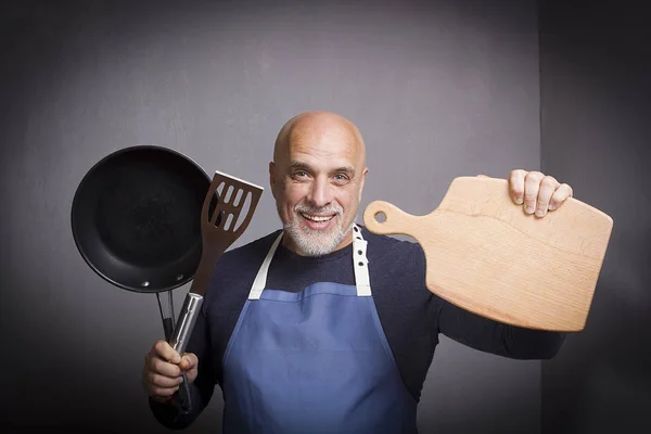 Uomo dai capelli grigi con attrezzatura da cucina — Foto Stock