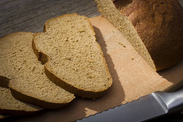 Pão fatiado em uma tábua de corte — Fotografia de Stock
