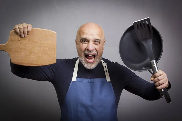 Grauhaariger Mann mit Küchenutensilien — Stockfoto