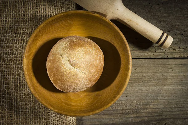 Rolo de pão em uma placa de madeira — Fotografia de Stock