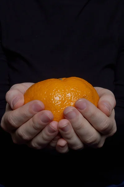 Hands with tangerine — Stock Photo, Image