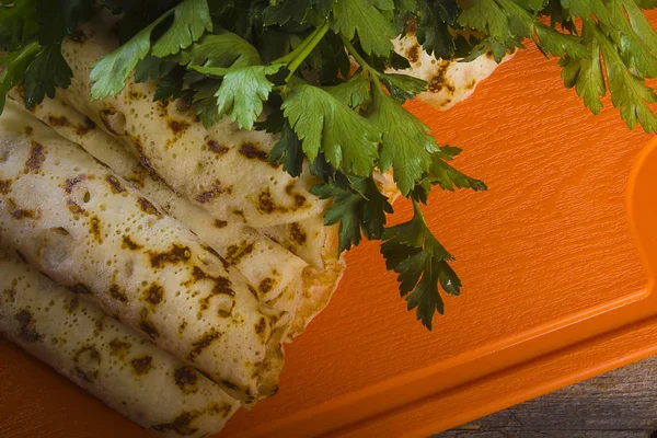 オレンジボード上のパセリで飾られたパンケーキ — ストック写真