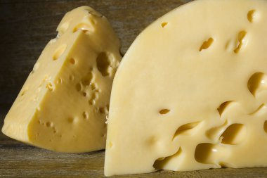 Eski ahşap arka planda peynir parçaları.