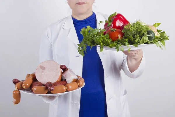 Nutritionist doctor with food plates on white background