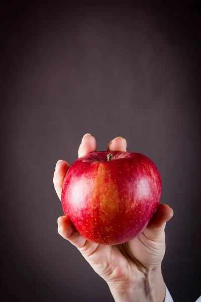 Weibliche Hand Hält Einen Apfel Auf Schwarzem Hintergrund — Stockfoto