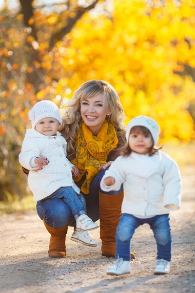 Mamá y dos niñas caminando en el parque en otoño —  Fotos de Stock