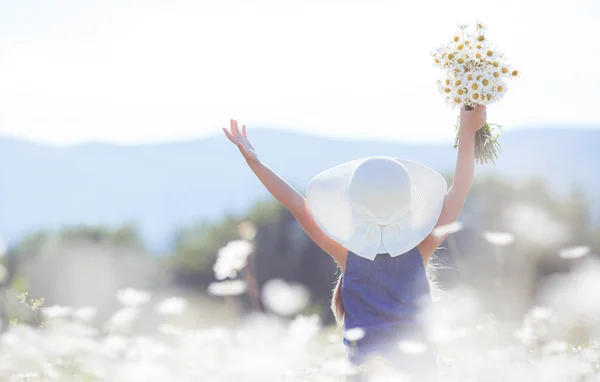 Retrato de verano de una niña en un campo de margaritas blancas . — Foto de Stock