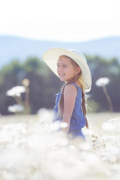 Beyaz papatya dolu bir alanda küçük bir kız portresi yaz. — Stok fotoğraf