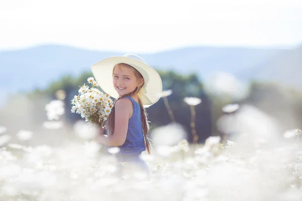 Portrait estival d'une petite fille dans un champ de marguerites blanches . — Photo