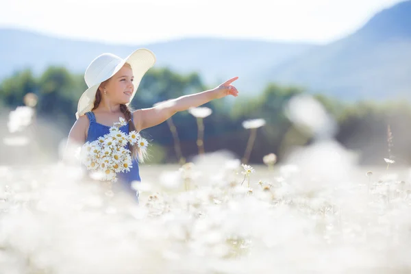 Sommerporträt eines kleinen Mädchens in einem Feld aus weißen Gänseblümchen. — Stockfoto