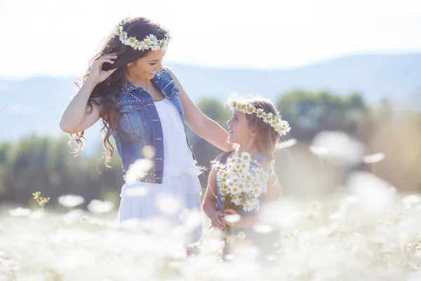 Madre e hija en el campo de verano de las margaritas florecientes — Foto de Stock
